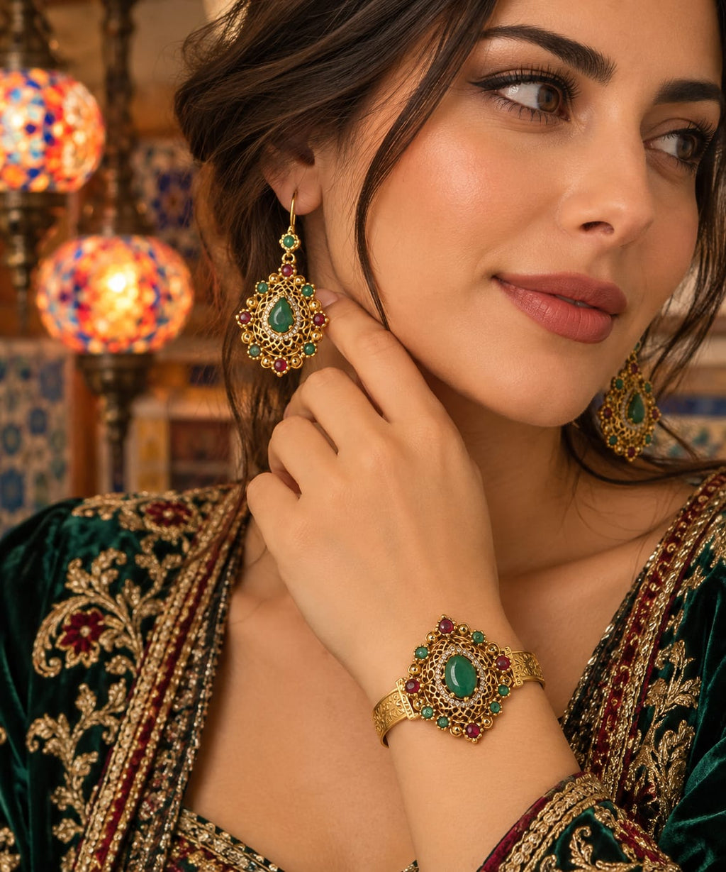 Parure Héritage Émeraude — Bracelet manchette en filigrane d’or orné et boucles d’oreilles pendantes assorties, agrémentés d’émeraudes centrales et de touches de rubis